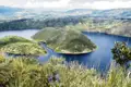 Panoramablick auf den Kratersee mit seinen bewaldeten Inseln und der umliegenden Landschaft.
