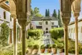 Die kunstvollen Bögen und Säulen der Alhambra rahmen den Blick auf den Garten und den Brunnen ein.