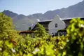 Südafrikanische Weine sind weltbekannt für ihre kräftigen Aromen. Unsere Rundreise beinhaltet auch eine Weinprobe. Vielleicht auf einem Weingut wie diesem in kapholländischer Architektur in den Weinbergen der Kapregion.