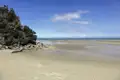 Strand bei Ebbe mit Felsen und Blick auf das Meer.