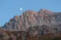 Felsige Berglandschaft im Abendlicht mit dem Mond am Himmel.