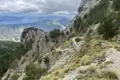 Schmaler Bergpfad mit Blick auf eine Bucht im Hintergrund.