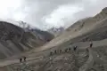 Wandergruppe auf einem Bergpfad in einer kargen, felsigen Landschaft.