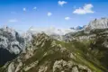 Berglandschaft mit grünen Hängen und felsigen Gipfeln.