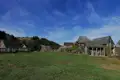 Rustikale Berghütten mit Holzzäunen und einer Berglandschaft im Hintergrund.