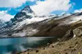 Ein ruhiger Bergsee am Fuße eines schneebedeckten Gipfels.