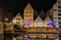 Historische Fachwerkhäuser am Kanal bei Nacht beleuchtet.