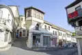 Szene einer Straße mit traditionellen albanischen Häusern, die die lokale Architektur zeigt.
