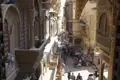 Eine belebte Straße mit traditionellen, verzierten Gebäuden und Händlern, die ihre Waren anbieten.