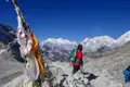 Wanderer auf einem Bergpfad mit Blick auf schneebedeckte Gipfel.