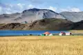 See mit Häusern und Bergen im Hintergrund.