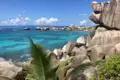 Türkisblaues Wasser und Granitfelsen an einer tropischen Küste.