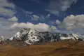 Schneebedeckte Bergkette in einer trockenen Landschaft.