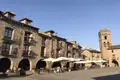 Marktplatz mit Steingebäuden und Kirchturm.