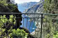 Ausblick von einem Balkon auf die Amalfiküste. Das Meer und die steilen Klippen sind im Hintergrund zu sehen.