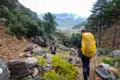 Zwei Wanderer auf einem Bergpfad mit Blick auf das Tal.