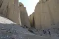 Wanderer auf einem steinigen Pfad in einer engen Schlucht.