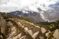 Steintreppe auf dem Inka Trail mit Blick auf das Urubamba-Tal und die umliegenden Berge.