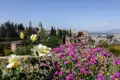 Blick auf die Alhambra von den Gärten aus, mit bunten Blumen im Vordergrund.