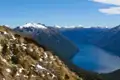 Panoramablick auf einen Bergsee und schneebedeckte Gipfel.
