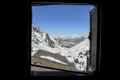 Blick aus dem Fenster auf eine verschneite Bergkette.