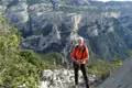 Wanderer auf einem Bergpfad mit Blick auf eine Schlucht.