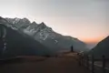 Aussichtspunkt mit Blick auf schneebedeckte Berge und Täler im Morgengrauen.