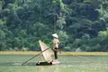Traditionelles Fischen auf einem Bambusfloß mit Netz und Kegelhut.