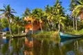 Haus am Wasser mit Palmen und Booten.