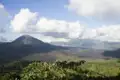 Vulkan und Caldera unter Wolkenhimmel.