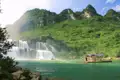 Besucher auf einem Floß vor einem Wasserfall.
