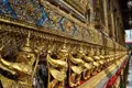 Goldene Garuda-Statuen an einer Tempelwand.