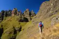 Wanderer auf einem Bergpfad mit Blick auf Felsformationen.