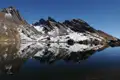 Stille Berglandschaft mit einem See, der die schneebedeckten Gipfel spiegelt.