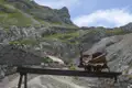 Berghütte in den Bergen mit einem alten Minenwagen, der auf die Nähe der Hütte hinweist.