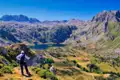 Wanderer betrachtet Bergsee und Landschaft.