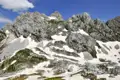Schroffe Felslandschaft mit Schneefeldern in den Bergen.