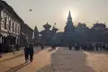Tempel und Gebäude auf einem Platz bei Sonnenaufgang.