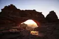 Sonnenaufgang durch einen natürlichen Felsbogen während der Reise.