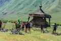 Radfahrergruppe pausiert während ihrer Tour an einem traditionellen Bauwerk in den Bergen.
