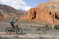 Mountainbiker fährt auf einem Weg vor einer Felsformation.