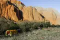 Campingplatz in einer bergigen Landschaft mit orangefarbenen Felsformationen.