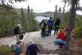 Wanderer ruhen sich auf einem felsigen Aussichtspunkt mit Blick auf die Küste aus.