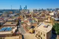Panoramablick auf die Altstadt von Baku mit ihren historischen Gebäuden und den modernen Flame Towers im Hintergrund.