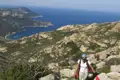 Wanderer auf einem markierten Küstenpfad mit Blick auf das Meer und die Buchten.