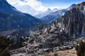 Traditionelles Bergdorf im Himalaya, umgeben von beeindruckender Berglandschaft.