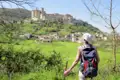 Wanderer mit Blick auf ein italienisches Bergdorf.