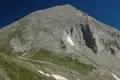Felsiger Berggipfel mit Schneefeldern.