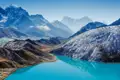 Türkisfarbener See und schneebedeckte Berge.