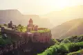 Historische Klosteranlage in bergiger Landschaft bei Sonnenuntergang.